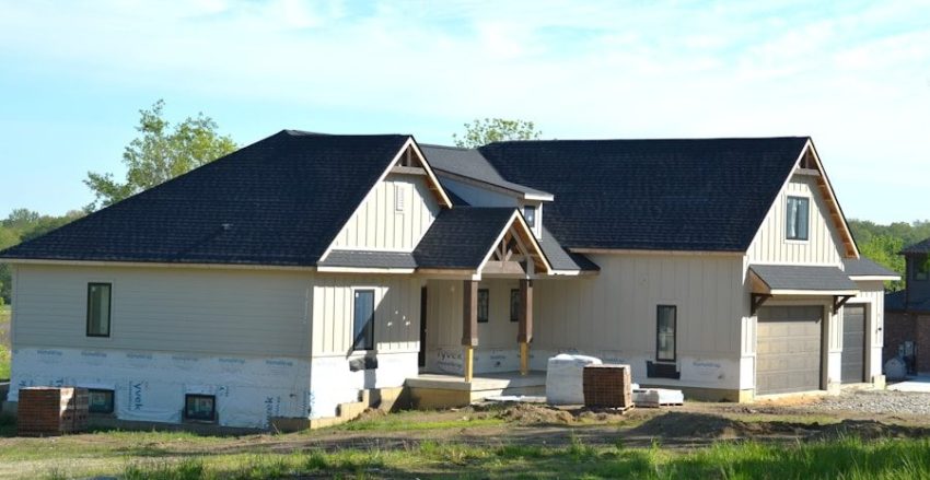 A new house under construction with a dark roof.