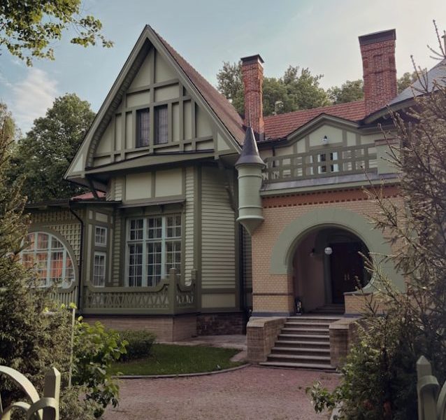 Historic green and yellow house with a grand arched entrance