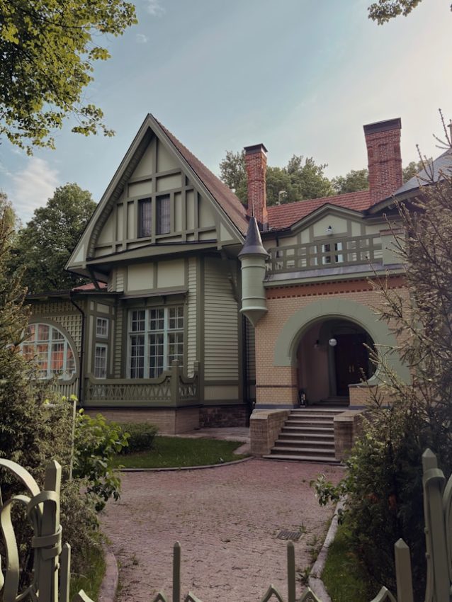 Historic green and yellow house with a grand arched entrance