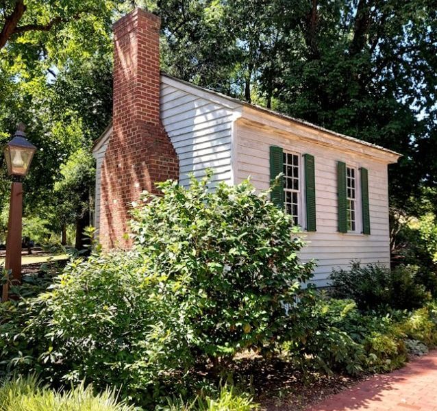 brown brick house near green trees during daytime