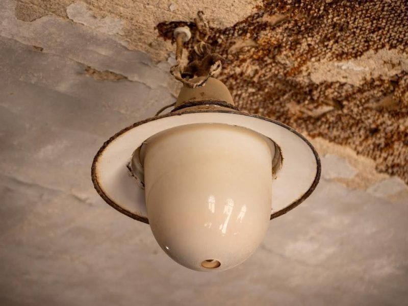 A water-damaged ceiling with staining and peeling paint
