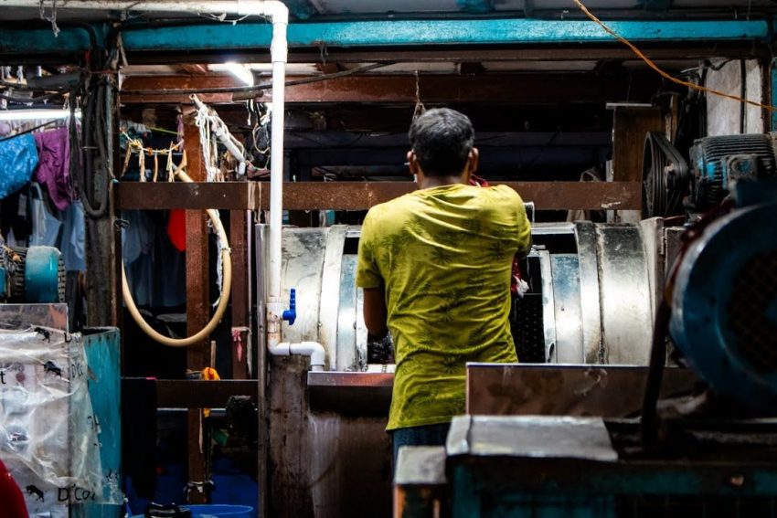 A worker drying out a room with fans and equipment after a leak