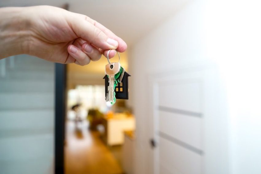 Holding house keys in front of the entrance