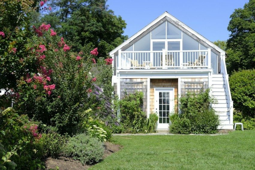 A white house with a porch and a deck