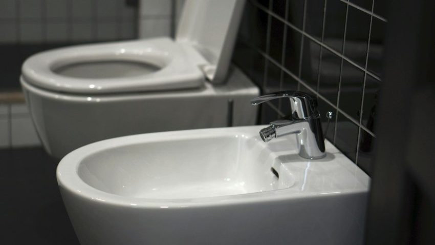 A white toilet sitting next to a white sink
