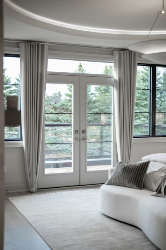 Modern bedroom with large windows and balcony access